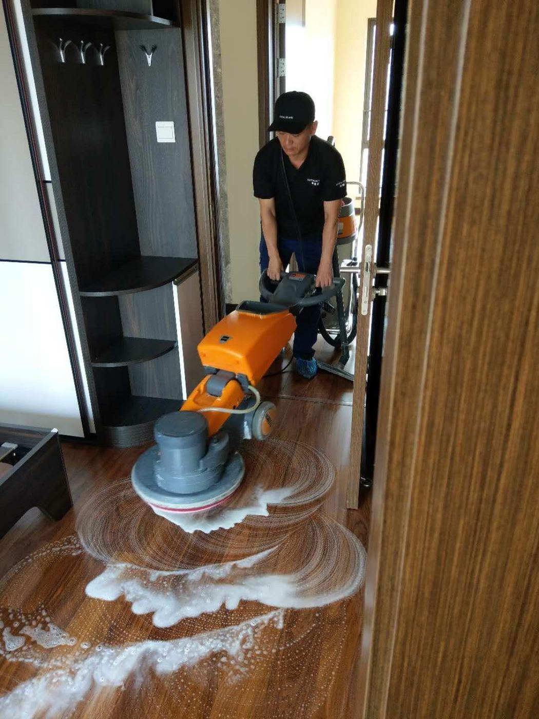 深圳木地板打蜡养护现场 — 黑围裙技师操作打蜡机清洗木地板
